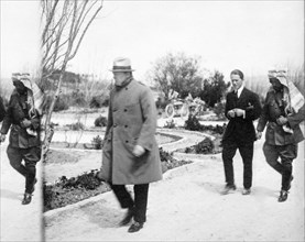 British Secretary of State for the Colonies Winston Churchill walking ahead of T.E. Lawrence and Emir Abdullah in the garden of Government House