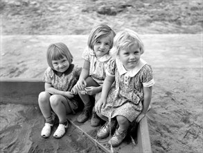 Three children playing in sandbox