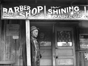 Coal miner standing outside barber shop