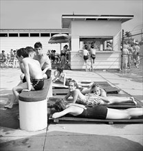 Teen sunbathers at community swimming pool