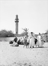 Group of Muslims with minaret in background