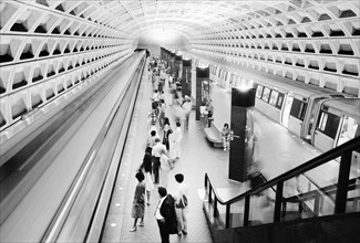 Commuters on train platform with train at Foggy Bottom Metro Station