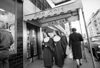 Two nuns walking under entrance canopy to Bon Soir nightclub