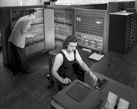 Man and woman working with IBM type T04 electronic data processing machine