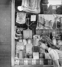Young girl looking in window of Jewish shop, Broome Street, New York City, New York, USA, Marjory