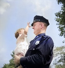 Irish-American policeman holding child, Central Park, New York City, New York, USA, Marjory