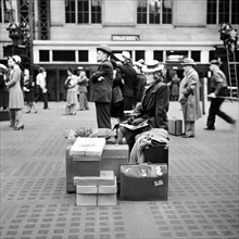 Woman sitting on luggage while waiting for train, Pennsylvania Station, New York City, New York,