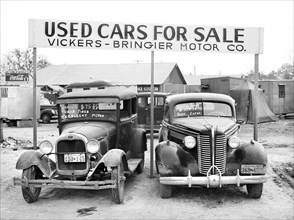 Used cars for sale with signs and prices at service station on main highway near Alexandria,
