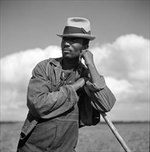 Agricultural worker resting while hoeing cotton on Allen Plantation, operated by Natchitoches