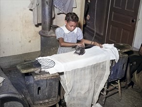 Young girl ironing, family is on governmetn relief, Chicago, Illinois, USA, Russell Lee, U.S. Farm