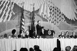 U.S. President Richard Nixon and U.S. First Lady Pat Nixon, both sitting left on dais, listening to