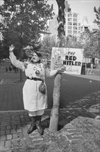 Man dressed as Adolf Hitler with sign reading "The Red Hitler," protesting the visit of Soviet