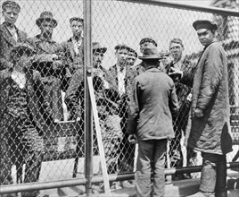 Immigrants scheduled for deportation being held in detention pen on roof of main building, Ellis