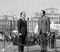 U.S. President Richard Nixon and King Hussein of Jordan standing on raised platform in front of Old