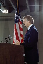 U.S. President Jimmy Carter at podium during news conference, three-quarter length profile