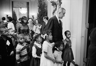 U.S. President Lyndon Johnson accompanying children of poverty to party at White House, Washington,