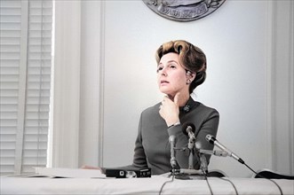 Phyllis Schlafly, chairwoman of the Stop ERA organization, seated at table, behind microphones,