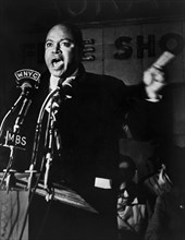 James Farmer, American civil rights activist, speaking before microphones outside Hotel Theresa,