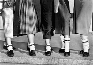 Legs and feet of five teenage girls wearing dog collar anklets on their socks, New York City, New