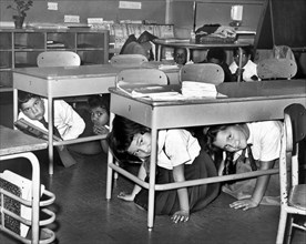 Young schoolchildren crawl under desks during air raid drill, P.S. 58, Carroll & Smith Streets,