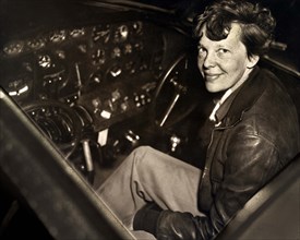 Amelia Earhart sitting in the cockpit of an Electra airplane, Acme Pictures, 1930's