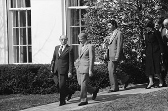 President Jimmy Carter, Israeli Prime Minister Menachem Begin and others walking outside while