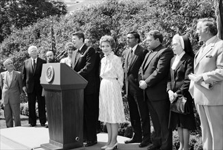 U.S. President Ronald Reagan standing at lectern with U.S. First Lady Nancy Reagan and others