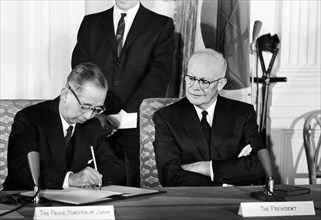 Prime Minister Nobusuke Kishi of Japan signing Mutual Cooperation and Security Treaty while seated