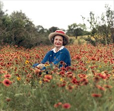 Former U.S. First Lady Lady Bird Johnson sitting in field of wildflowers, Texas, USA, Frank Wolfe,