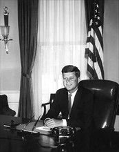 U.S. President John Kennedy at his desk (first White House photograph made of the President at his