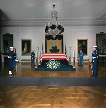 Late U.S. President John Kennedy’s flag-draped casket, members of honor guard standing watch, East