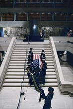 Military officers carrying former U.S. President Lyndon B. Johnson's casket up steps in the Great