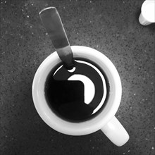 Cup of coffee and spoon, high angle view