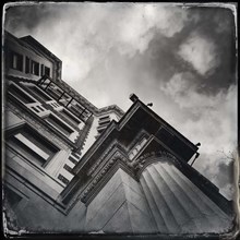 Old urban building exterior, low angle view against sky and clouds