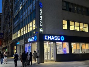 Chase retail bank office, building exterior and street scene at night, New York City, New York, USA