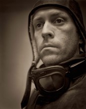 Head and shoulders portrait of mid-adult man wearing vintage pilot outfit