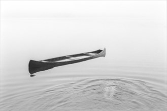 Unrecognizable person swimming underwater towards a flooded canoe