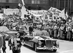 U.S. President John F. Kennedy waving to crowd from convertible car during motorcade to Los Pinos,