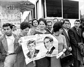 Spectators holding sign to greet U.S. President John F. Kennedy during his motorcade to Los Pinos,