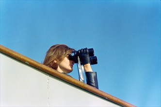 U.S. First Lady Jacqueline Kennedy watching through binoculars fourth  race of America's Cup from