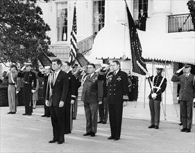 U.S. President John F. Kennedy (left, foreground) attending military reception in honor of