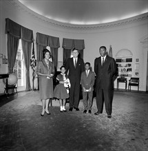 U.S. President John F. Kennedy (center) visiting with Myrlie Evers (far left), widow of civil