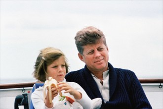 U.S. President John F. Kennedy sitting next to his daughter, Caroline Kennedy, aboard the