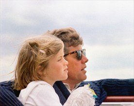 Head and shoulders profile portrait of U.S. President John F. Kennedy sitting next to his daughter,