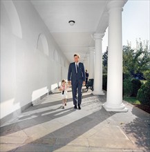 U.S. President John F. Kennedy walking with his son, John F. Kennedy, Jr. (carrying a soda bottle),