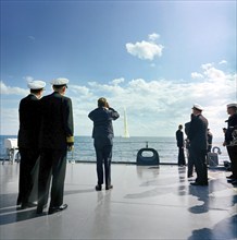 U.S. President John F. Kennedy (rear view, center left) aboard the U.S. Naval ship USS Observation