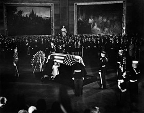 Jacqueline Kennedy and daughter Caroline Kennedy kneel and kiss U.S. President John F. Kennedy's