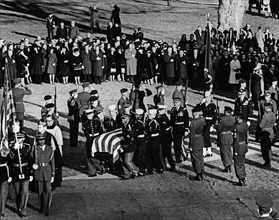 Honor guard pallbearers carrying flag-draped casket of U.S. President John F. Kennedy to gravesite,