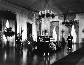 Late U.S. President John Kennedy’s flag-draped casket, members of honor guard standing watch, East