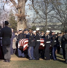 Honor guard pallbearers carrying flag-draped casket of U.S. President John F. Kennedy to gravesite,